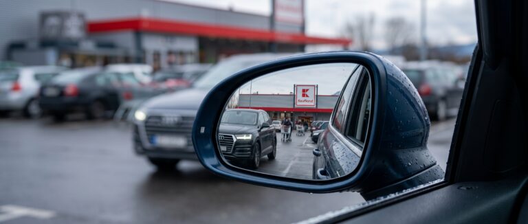Parkplatzunfall wer zahlt Autos beim Ausparken stoßen zusammen. Sicht aus dem Rückspiegel